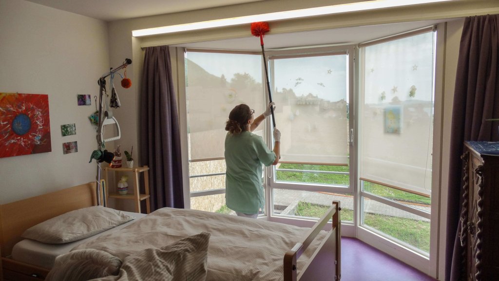 Une femme en train de nettoyer une chambre.